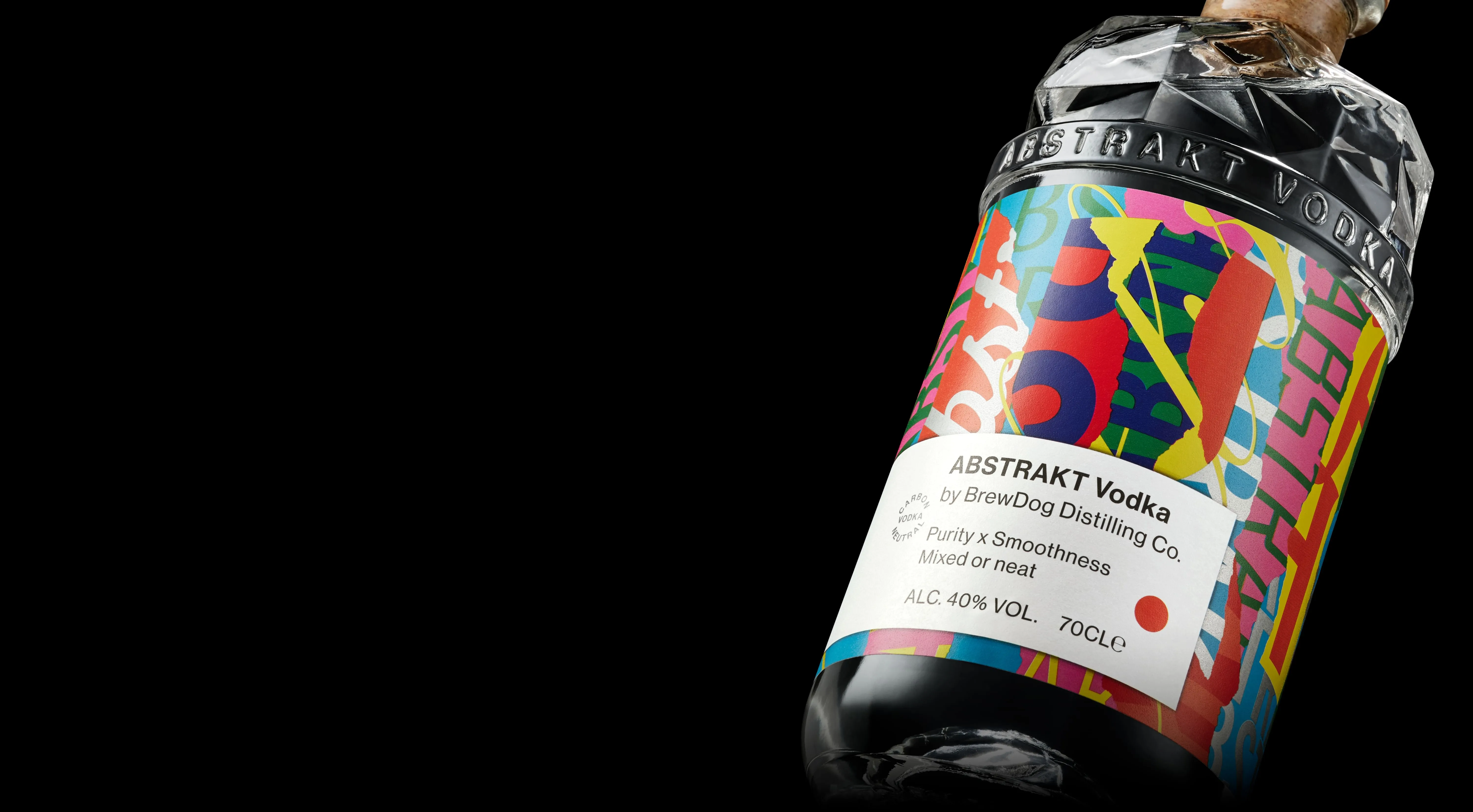 Abstrakt Vodka bottle on a black background. The shoulder is covered in geometric faceting. Below is a band of embossed glass reading Abstrakt Vodka. Running further down the bottle is a label of abstract shapes, colours, and typefaces. The corked stopper reads Brewdog Distilling Co.